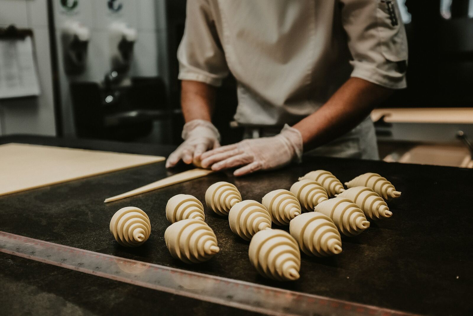 Pastry Zone — pasticciere che arrotola i cornetti sul banco