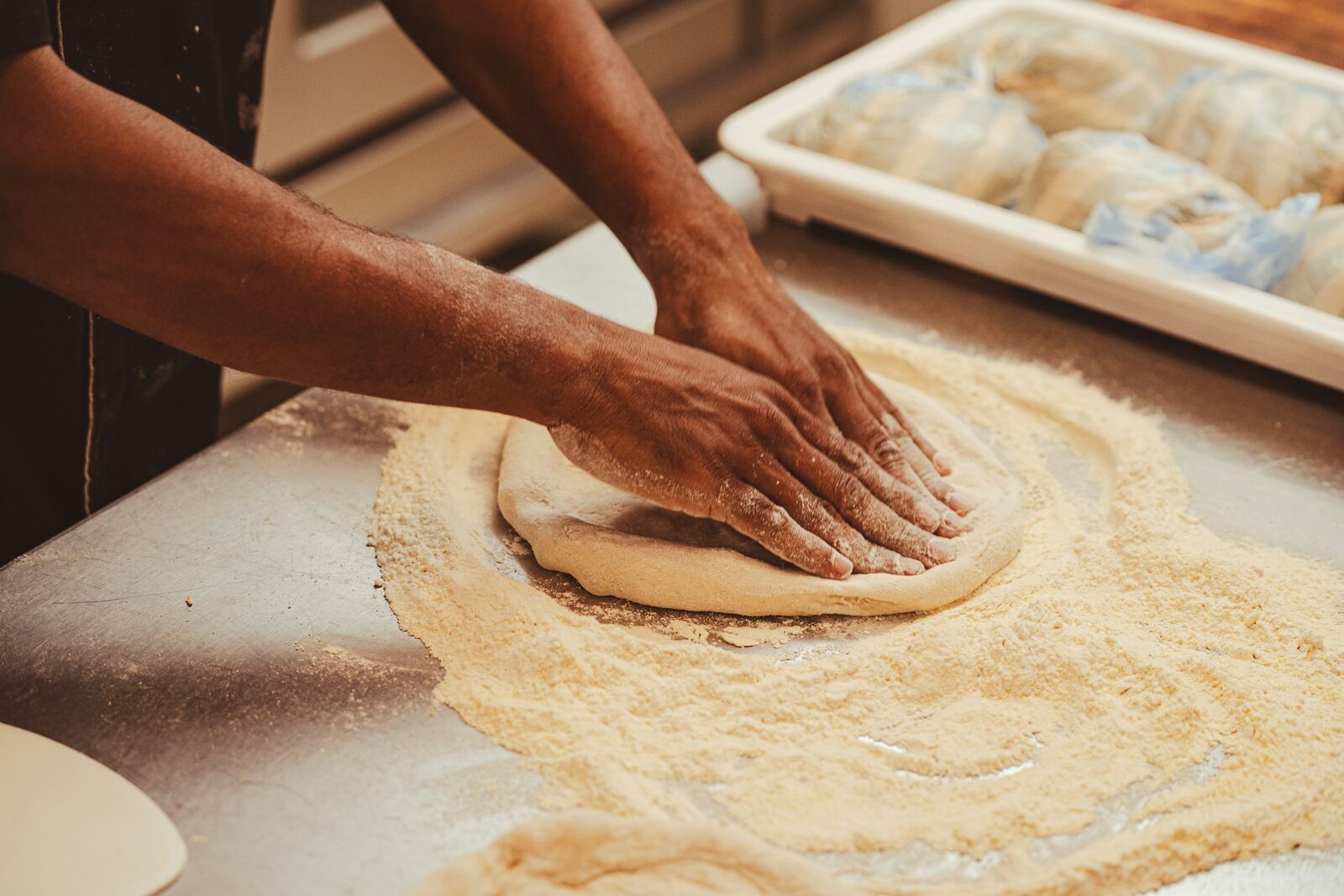 Pizza Concept — mani che stendono l'impasto sul banco infarinato
