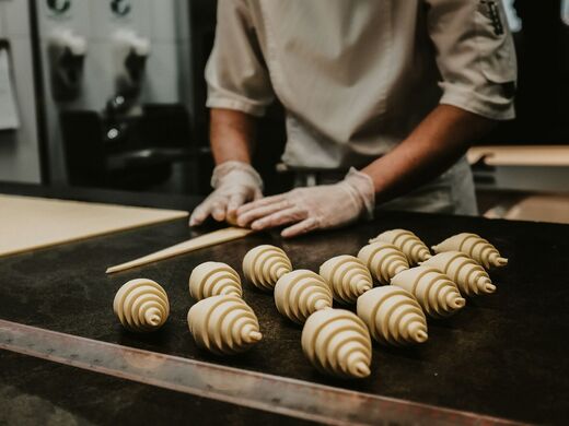 Pasticciere che arrotola i cornetti