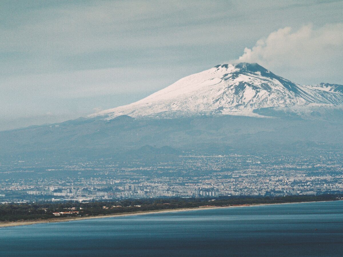 L'Etna innevato sopra Catania e la costa: Misterbianco è ai piedi del vulcano